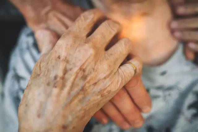 Foto genérica com foco nas mãos de uma mulher idosa