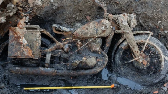 Çamura saplanmış motosiklet görüntüsü.