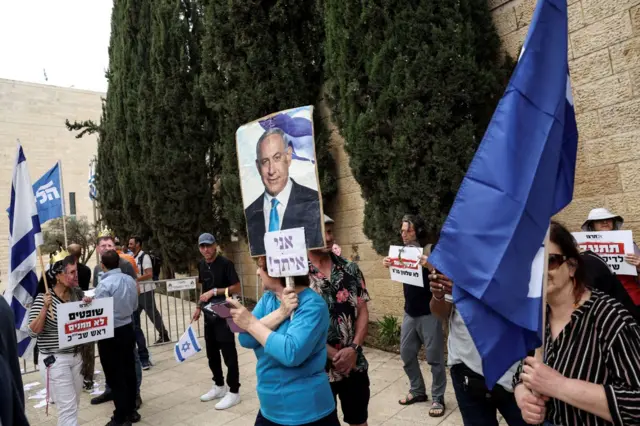 Simpatizantes de Benjamin Netanyahu en Jerusalén con carteles que muestran la foto del primer ministro junto al mensaje "Estoy contigo", el 8 de abril de 2025.