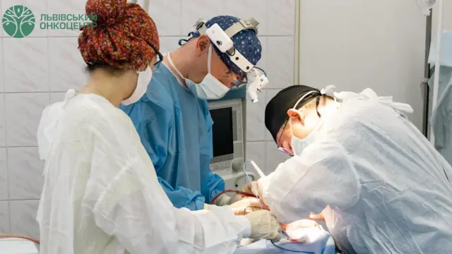 Лікар схилився над пацієнтом, якому вирізають пухлину