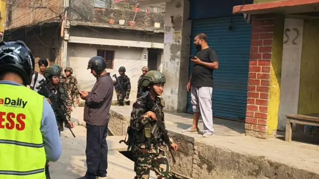 वीरगन्जको सडकमा सुरक्षा गस्ती गर्दै नेपाली सेनाका जवानहरू, बाटोमा सञ्चारकर्मी र अन्य व्यक्तिहरू पनि देखिन्छन्