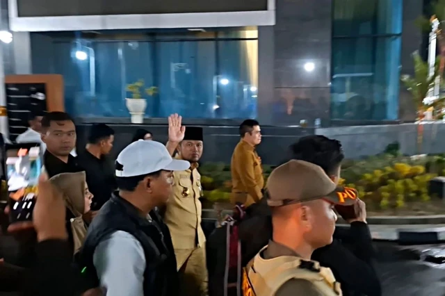 Gubernur Kalimantan Timur, Rudy Masud, berjalan meninggalkan Kantor Gubernur Kalimantan Timur menuju rumah jabatan dengan pengawalan aparat, Selasa (21/4/2026) malam, tanpa memberikan keterangan kepada wartawan usai aksi unjuk rasa berujung ricuh.