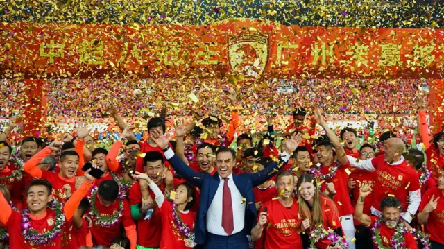 2019年12月1日、中国広東省広州市で、広州FCの中国スーパーリーグ優勝を祝うヘッドコーチと選手ら。金とピンクの紙吹雪が舞っている