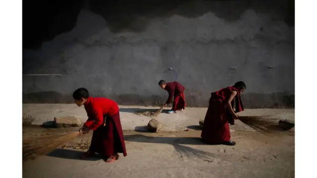 Biksu menyapu lantai di Kathmandu, Nepal