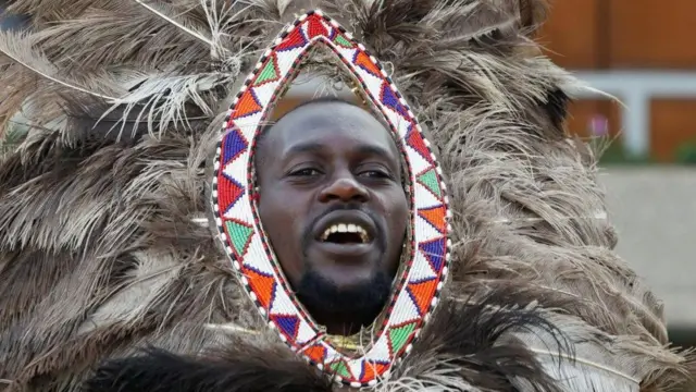 Umugabo wo mu basangwabutaka b'aba-Maasai yambaye amoya y'inyoni yitwa otriche , 6 Nyakanga