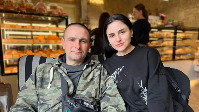 Ліворуч - у чорній футболці та камуфляжній куртці Олександр Савов. Праворуч - його донька Анастасія в чорному светрі з білими візерунками. Вони посміхаються, дивлячись у камеру