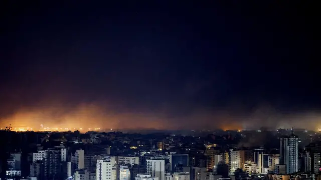 Prédios com fogo atrás, durante a noite