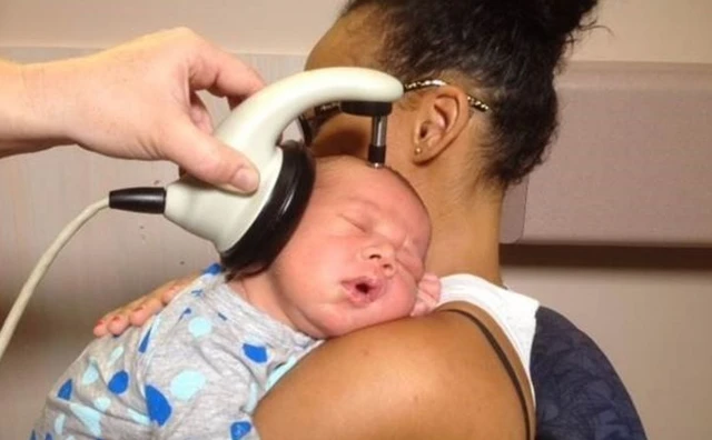 แพทย์ใช้เครื่องมือทดสอบการได้ยินของเด็กทารก