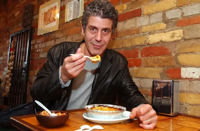 El chef Anthony Bourdain prueba el pastel de choclo chileno en el restaurante Jumbo Empanadas, en Kensington Market (Toronto), el martes 2 de abril de 2002.