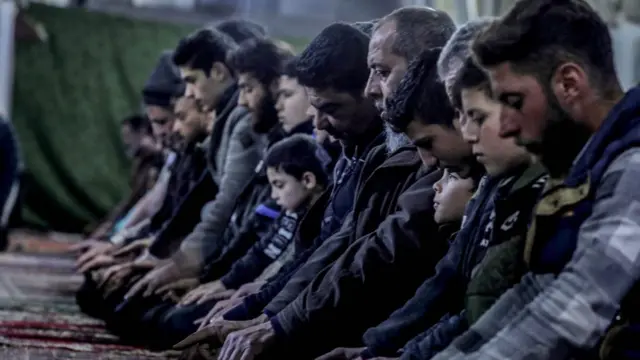 Umat Muslim tiba di Masjid al-Kabir untuk melakukan solat tarawih pertama di bulan suci Ramadan di distrik Ma'arrat Misrin, Idlib, Suriah, Rabu (22/03). 