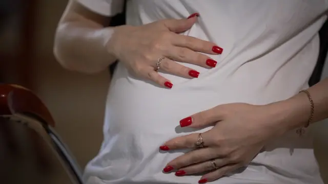 Sabina colocando as mãos na barriga de grávida