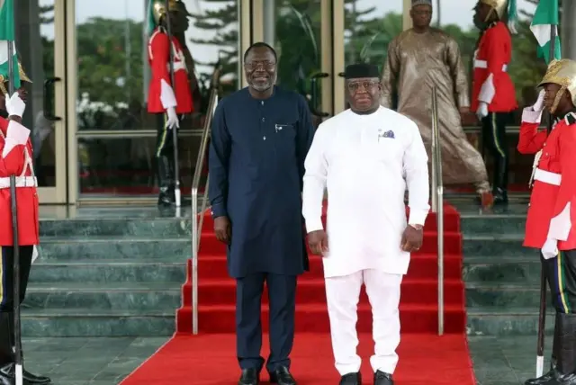 Le président de la Commission de la Communauté économique des États de l'Afrique de l'Ouest, Omar Touray (à gauche) est reçu par le président de la Sierra Leone, Julius Maada Bio (à droite), lors de la session extraordinaire des chefs d'État et de gouvernement de la Communauté économique des États de l'Afrique de l'Ouest (CEDEAO) à Abuja, le 10 août 2023.