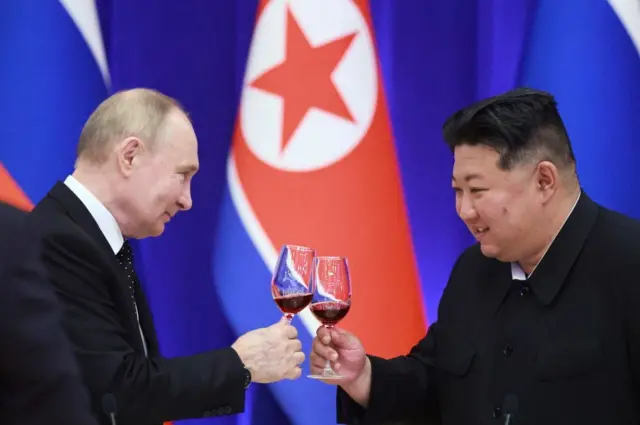 Vladimir Putin e Kim Jong Un brindando