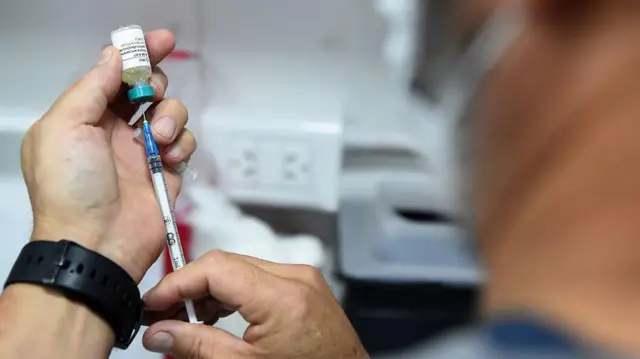 Un médico argentino mientras prepara una inyección