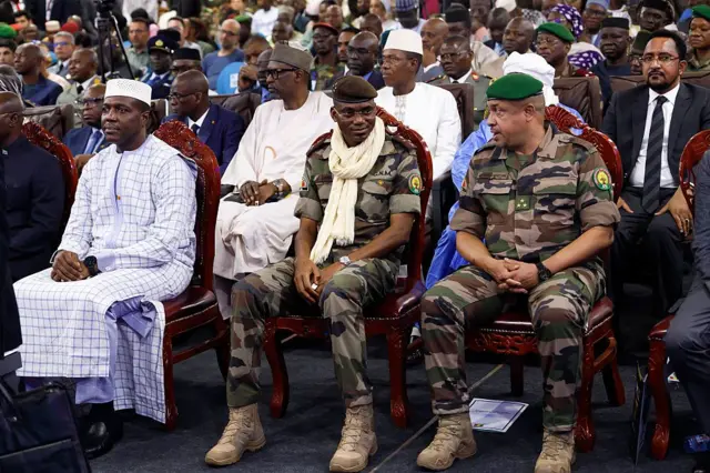 Le Premier ministre malien Abdoulaye Maïga (à gauche), le ministre de la Défense Sadio Camara (au centre) et le ministre de la Sécurité et de la Protection civile Daouda Aly Mohammedine (deuxième à droite) assistent à la journée d'ouverture du salon Bamex 25 à Bamako, le 11 novembre 2025. 