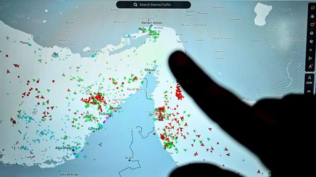 Seseorang menunjuk halaman di situs Marinetraffic yang menunjukkan lalu lintas kapal komersial di tepi Selat Hormuz dekat pantai Iran, di Paris pada 4 Maret 2026.