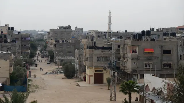 Bairro Brasil em Rafah em 2015, com ruas de terra e prédios baixos cinza em concreto aparente, sem acabamento