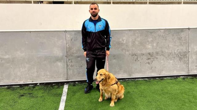 Darleyslots que pagam de verdadepé e usando agasalho acompanhadoslots que pagam de verdadesua cadela Clark, da raça Golden,slots que pagam de verdadeuma quadraslots que pagam de verdadefutebol com gramado sintético