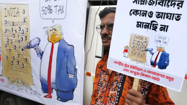 Человек с плакатом, изображающим Трампа с дрелью, протестует против повышенных пошлин