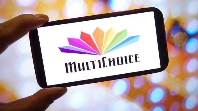Pesin dey hold phone wit di picture wey get multichoice brand on top