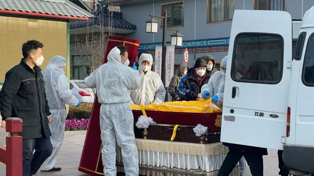 Nhân viên trong trang phục y tế di chuyển một thi hài