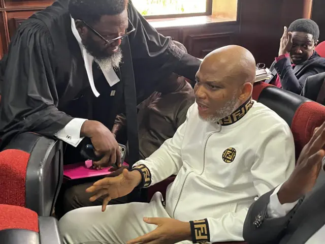 Nnamdi Kanu discussing with one of im lawyers Maxwell Opara for di courtroom before proceedings start.