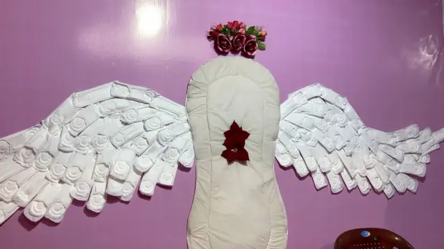 ঋতুস্রাবের দাগ সহ স্যানিটারি ন্যাপকিনের বড়সড় একটি মডেল লাগানো একটি শিবির আছে এই পুজোয় ঢোকার মুখে