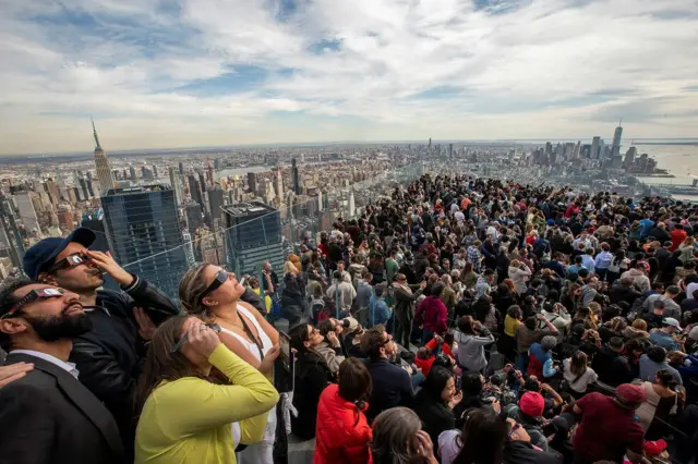 Multidão observando o eclipse com óculoscasas de apostas com bonus gratisproteção