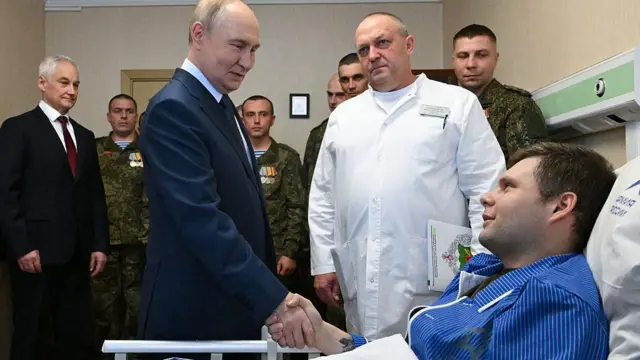 Na fotografiji Vladimir Putin se rukuje sa vojnikom u bolničkom krevetu, koji ima plavu pidžamu, u vojnoj bolnici u Moskvi u oktobru 2025. godine.