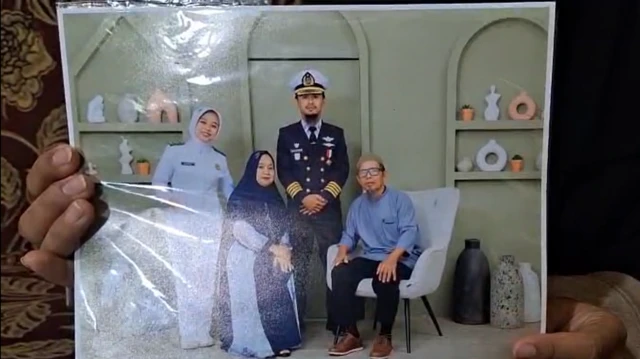 Santi Sanaya menunjukkan foto Ashari bersama keluarga.