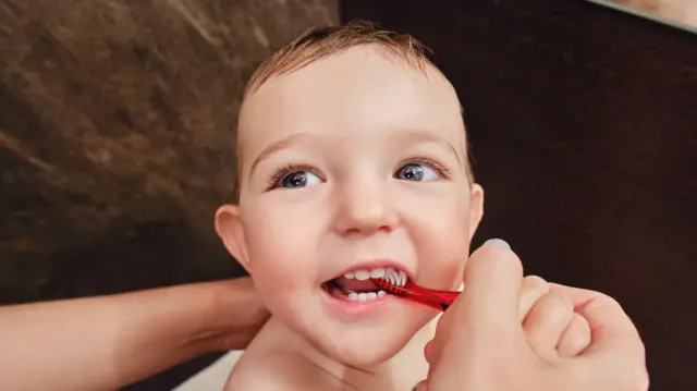 Niño con cepillo de dientes