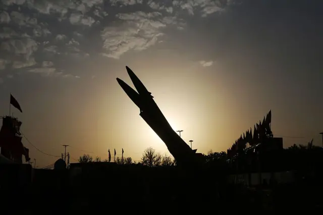 عُرضت صواريخ ذو الفقار وقدر، إلى جانب نموذج معدني لغواصة صغيرة، في ساحة آزادي، في ظل تصاعد حدة الهجمات المتبادلة بين إيران والولايات المتحدة.
يظهر في الصورة صاروخان، يبرزهما المصور بلون أسود وتظهر خلفهما الشمس.