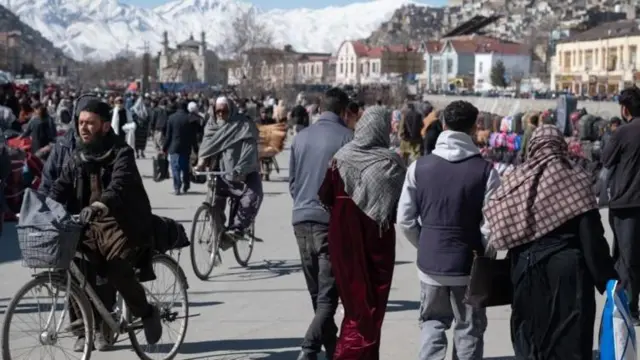 أناس يسيرون في ميدان عام في كابول