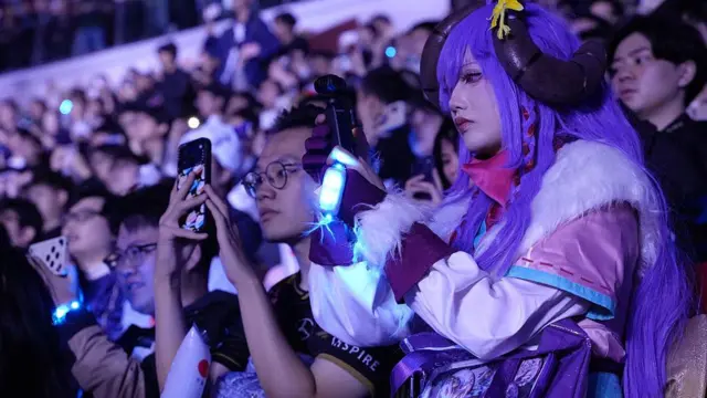 动漫穿着的亚洲电竞迷在看台上