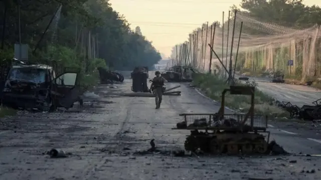 Солдат ЗСУ йде на фоні руїн по вулиці