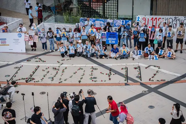 Protesters pose with portraits of activists during a vigil
BANGKOK, THAILAND - 2025/07/15: Protesters pose with portraits of activists during a vigil with red roses on the ground spelling out "Repeal 112," referencing Section 112 of the Thai Criminal Code. People gathered outside Bangkok Art and Culture Centre for a candlelight vigil titled "Light Up Hope for the People's Amnesty." Organized ahead of a parliamentary debate on the 16 July 2025, the event featured personal testimonies, portraits of 50 political detainees, and a red rose display reading "Amnesty 112." Participants called for the passage of a comprehensive amnesty bill covering cases under Section 112 of the Thai Criminal Code. (Photo by Ploy Phutpheng/SOPA Images/LightRocket via Getty Images)
