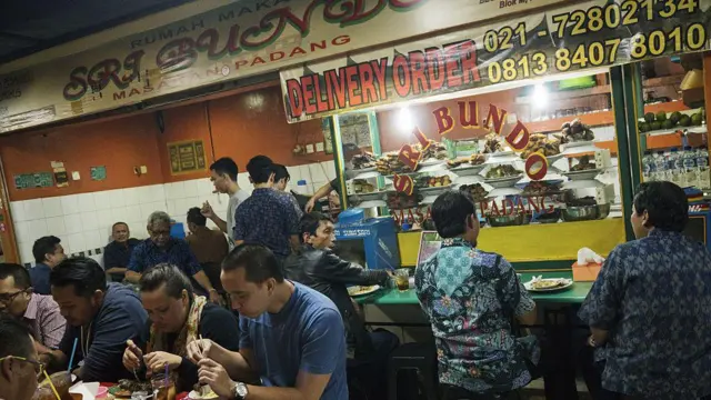 Pelanggan makan di dalam food court di kawasan Blok M, Jakarta, Indonesia, pada 28 Oktober 2016.