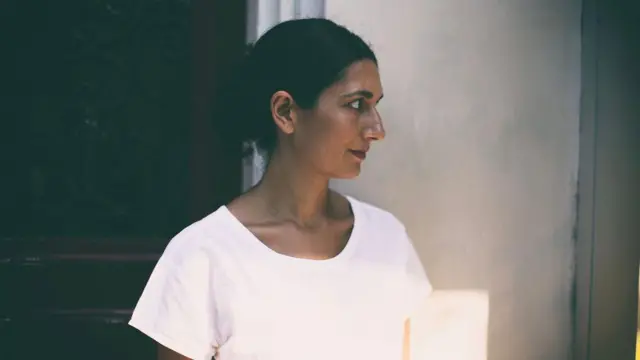 Ayşegül Savaş beyaz bir tişört giymiş, fotoğraf profilden çekilmiş