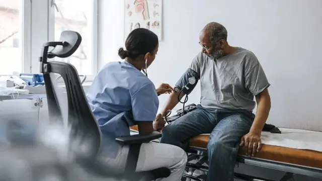 Un homme se fait consulter par une professionnelle de la santé.