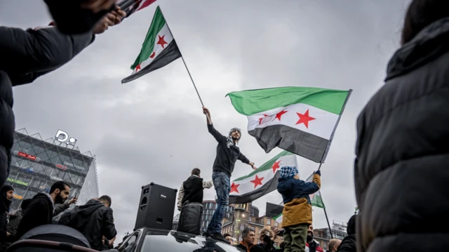 Masyarakat dan anggota Asosiasi Suriah di Denmark membawa bendera oposisi Suriah saat merayakan pengambilalihan Damaskus oleh pemberontak, di Kopenhagen, Denmark, pada 8 Desember 2024.
