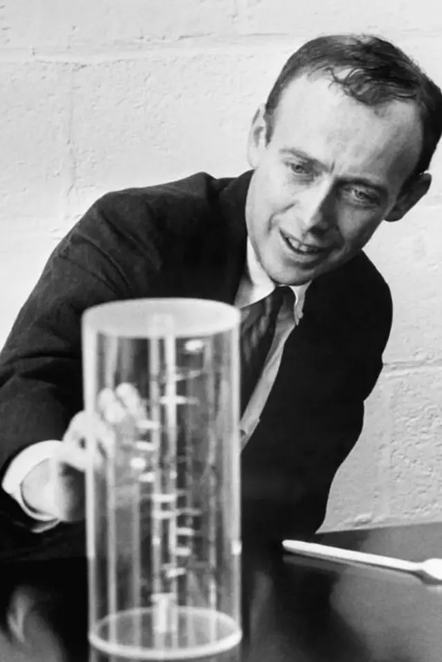 Watson James yitegereza kandi yerekana icyitegererezo cya ADN ku ubushakashatsi bwe muri laboratwari