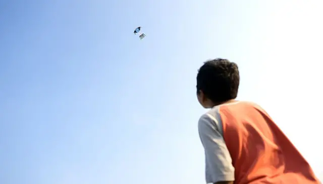 Seorang anak bermain layangan.