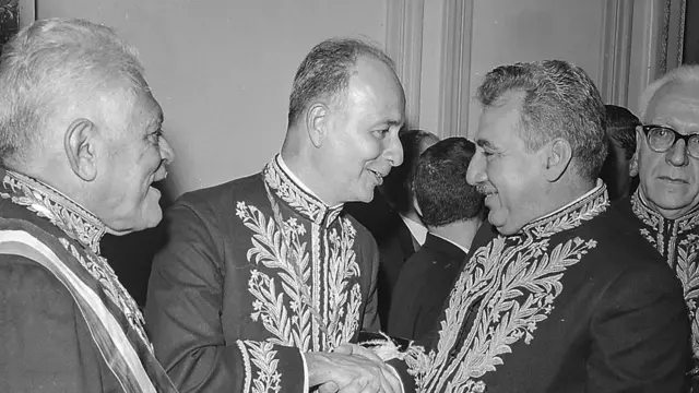 Adonias aparece ao centro cumprimentando Jorge Amado, com quem conversa.