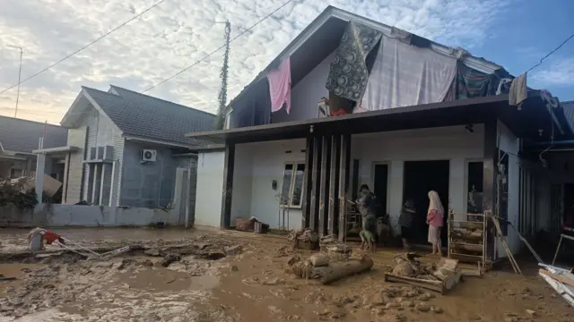 Rumah Arif di Kampung Dalam, Kecamatan Karang Baru, Aceh Tamiang, penuh lumpur. Selama dua hari mereka tinggal di atap. 