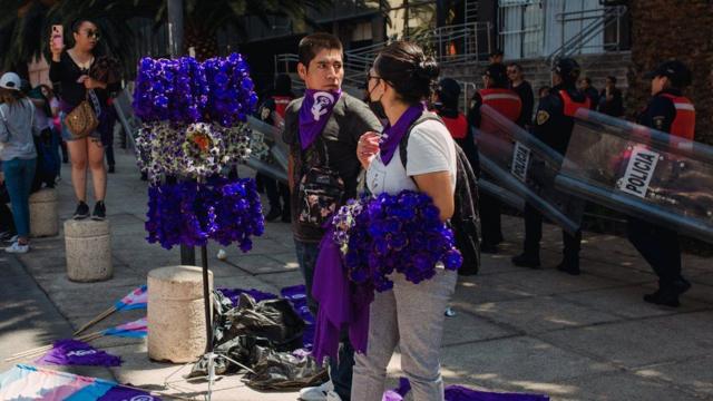 Des vendeurs ambulants proposent des colliers de fleurs violettes à l'occasion de la Journée internationale de la femme.