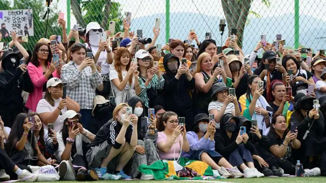 Hundreds of fans gathered near two army bases just outside of the capital Seoul where BTS band leader RM and singer V were discharged. Many held up their phones to photograph the duo as they showed up