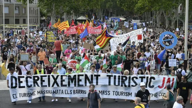 Dezenasbencb pokermanifestantes na rua; alguns deles, na frente, seguram grande faixa