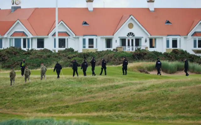 Шеренга військовослужбовців та поліцейських підмітає ділянку трави біля розкішного курорту Тернберрі
