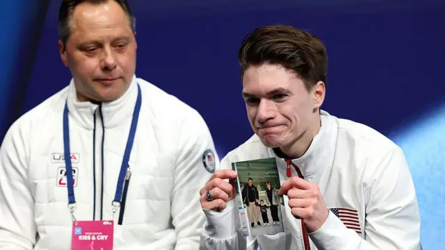 Наумов показує фото своїх загиблих батьків на Олімпіаді