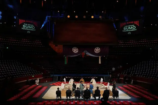 土俵わきに行司や関係者らが座り、土俵祭が行われている